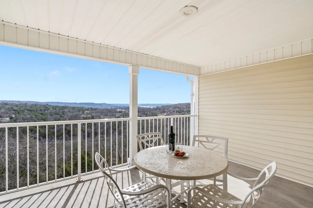 The image shows a serene outdoor seating area with a table set for wine and snacks, overlooking a tranquil lake view. The setting sun bathes the scene in warm, peaceful light, inviting guests to sit, relax, and enjoy the surrounding natural beauty.